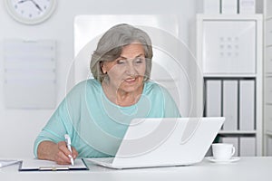 Senior business woman working in office with laptop