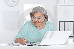 Senior business woman working in office with laptop