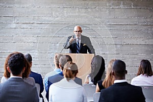 Senior Businessman Addressing Delegates At Conference