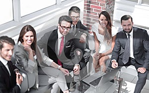 Senior businessman and business team sitting in the lobby of the modern office.