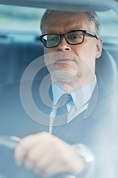 Senior businessman driving car