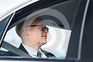 Senior businessman driving on car back seat