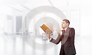 Senior businessman finger pointing into open book