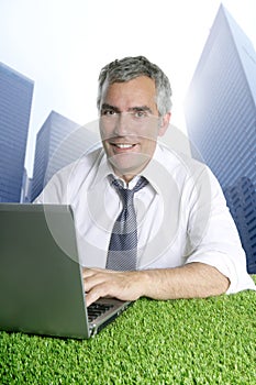 Senior businessman green grass city buildings