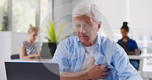 Senior businessman having heart attack in office