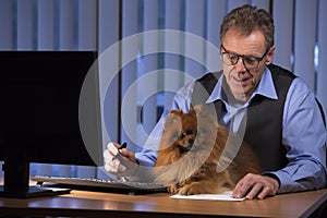 Senior businessman with his dog on the desk in an office