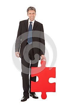 Senior businessman holding a jigsaw puzzle