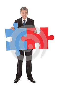 Senior businessman holding a jigsaw puzzle