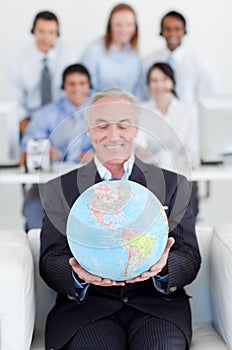 Senior businessman holding a terrestrial globe