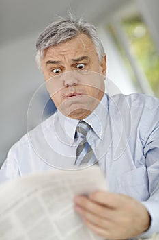 Senior businessman with horrified with news photo