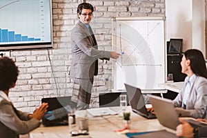 Businessman leading meeting at boardroom table