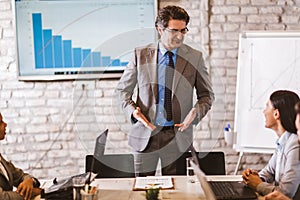 Businessman leading meeting at boardroom table