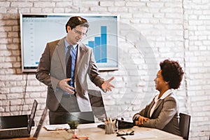 Businessman leading meeting at boardroom table