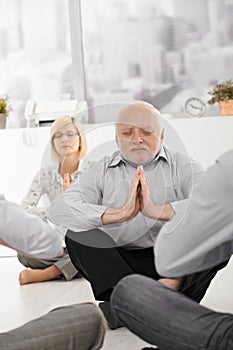 Senior businessman meditating in office