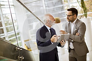 Senior businessman pointing and showing something to junior part