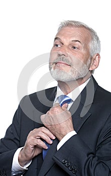 Senior businessman portrait adjusting necktie