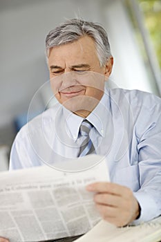 Senior businessman reading news