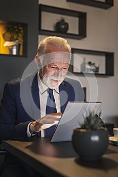Senior businessman reading news on tablet computer