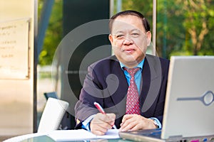 Senior businessman in suit writing proposal
