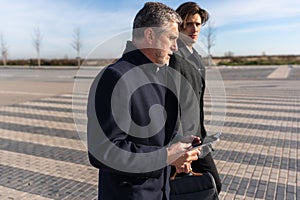 Senior businessman with tablet walking with colleague