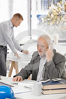 Senior businessman talking on landline phone