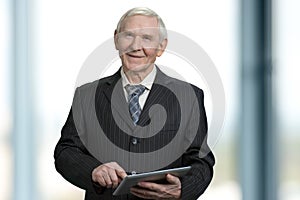 Senior businessman touching tablet screen.