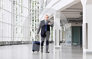 Senior businessman walking with travel bag