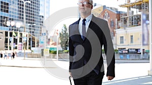Senior businessman walking with travel bag in city
