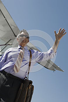 Senior Businessman Waving Hand At Airfield photo