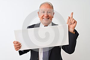 Senior businessman wearing suit holding banner over isolated white background surprised with an idea or question pointing finger