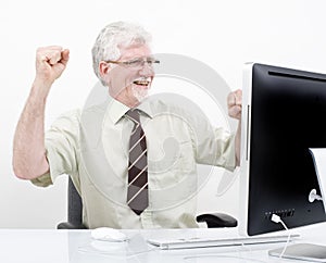 Senior businessman winning in front of computer