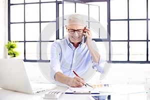 Senior businessman working on his notebook at home