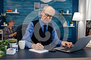 Senior businessman writing notes