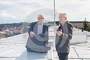 Senior businessmen discussing business deal on the roof of a building