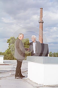 Senior businessmen handshaking while making a business deal on t