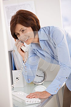 Senior businesswoman on landline phone call photo