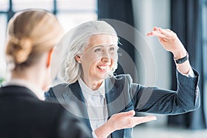 Senior businesswoman showing something to colleague on meeting