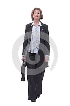 Senior businesswoman in suit walking towards carrying a briefcase