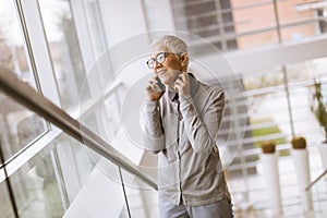 Senior businesswoman using mobile phone in modern ofice