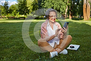 Senior businesswoman using mobile to solve problem while rest in park