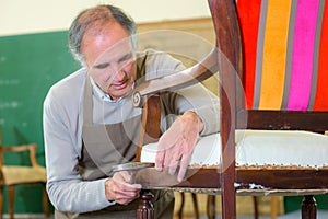 Senior cabinetmaker repairs chair