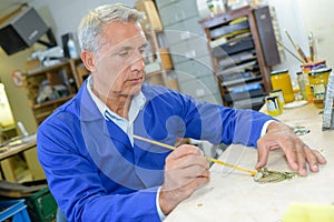 Senior carpenter planning work in workshop