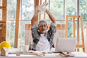 Senior carpenter relaxing at workplace.