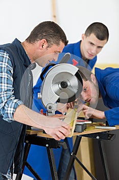 Senior carpenter with two apprentices learning