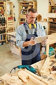 Senior Carpenter using Digital Tablet