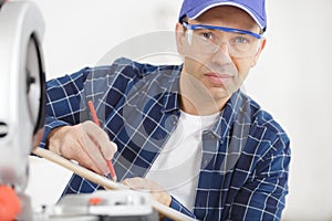 senior carpenter working with circular saw