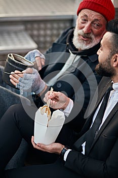 Senior caucasian beggar male telling story about life to businessman