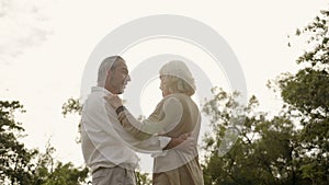 Senior Caucasian couple dancing in park. With a happy smile, feel relax with nature in the morning. Or in the evening. Is a family