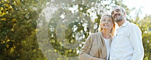 Senior Caucasian couple hugging in park. Family with a happy smile feels relaxed with nature