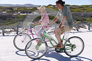 Senior Caucasian couple riding a bike at the beach